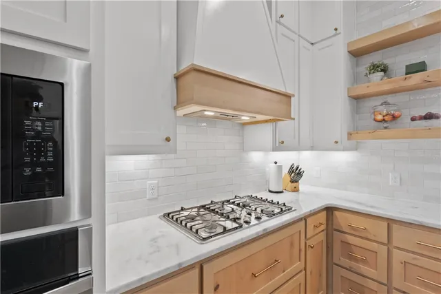 a kitchen with stainless steel appliances granite countertop a stove and white cabinets