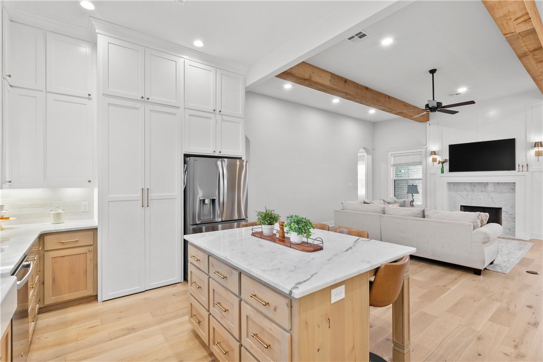 5001 Greenstone Way Bryan, TX 77802 - Photo 15 of 43 a kitchen with granite countertop a sink and a stove top oven with wooden floor