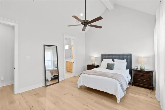 a bedroom with a beds chandelier and a window