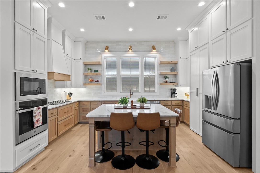 5001 Greenstone Way Bryan, TX 77802 - Photo 4 of 43 a kitchen with refrigerator cabinets dining table and chairs