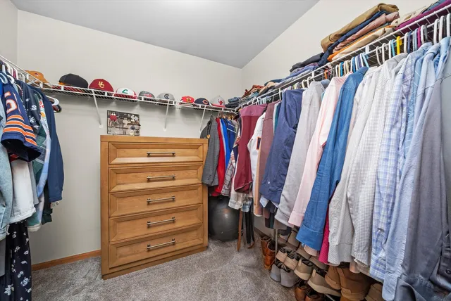 a view of walk in closet with clothes and shoes