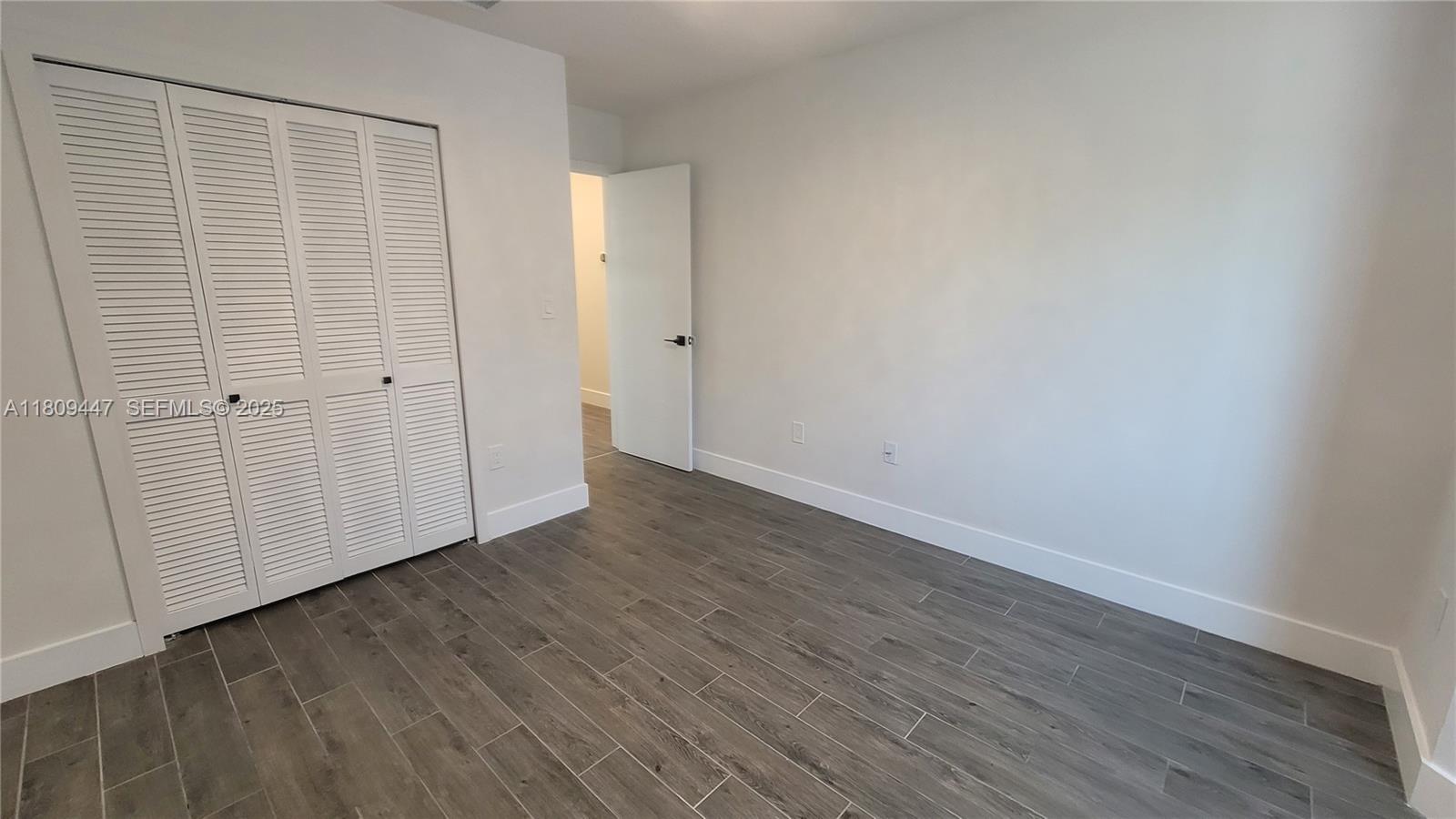 14641 Southwest 52nd Street Miami, FL 33175 - Photo 12 of 26 a view of an empty room with wooden floor and entryway