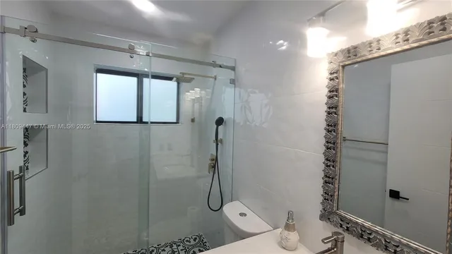a bathroom with a granite countertop toilet a sink and shower