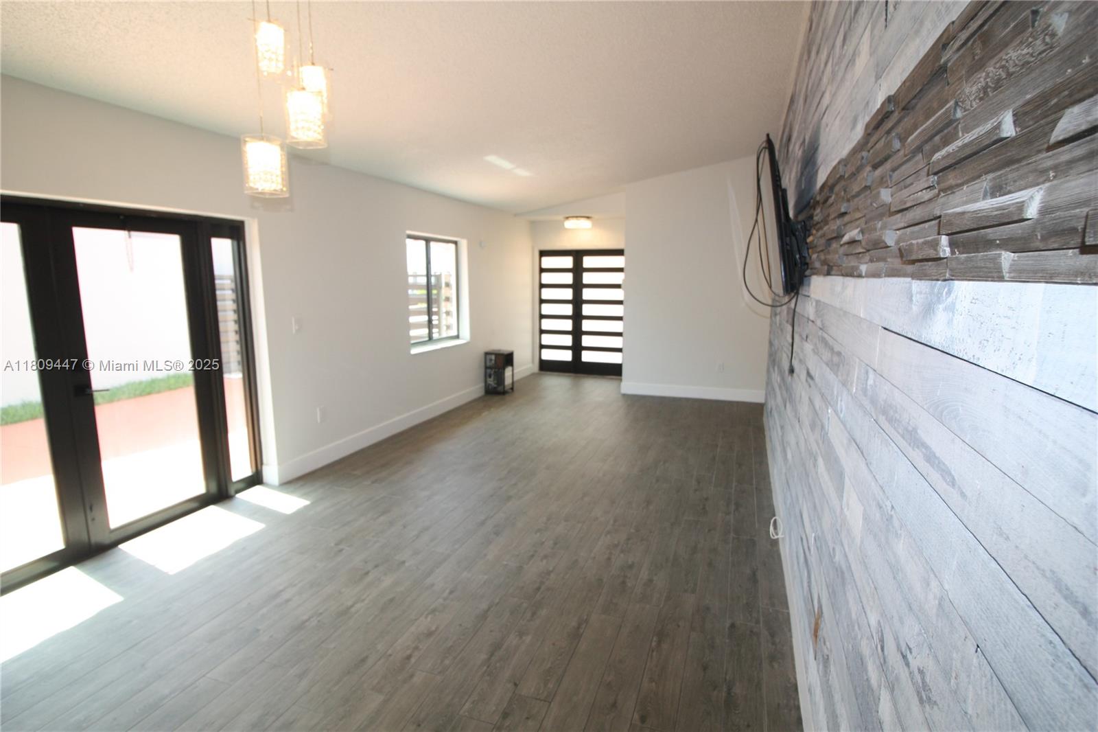 14641 Southwest 52nd Street Miami, FL 33175 - Photo 7 of 26 wooden floor in an empty room with a window