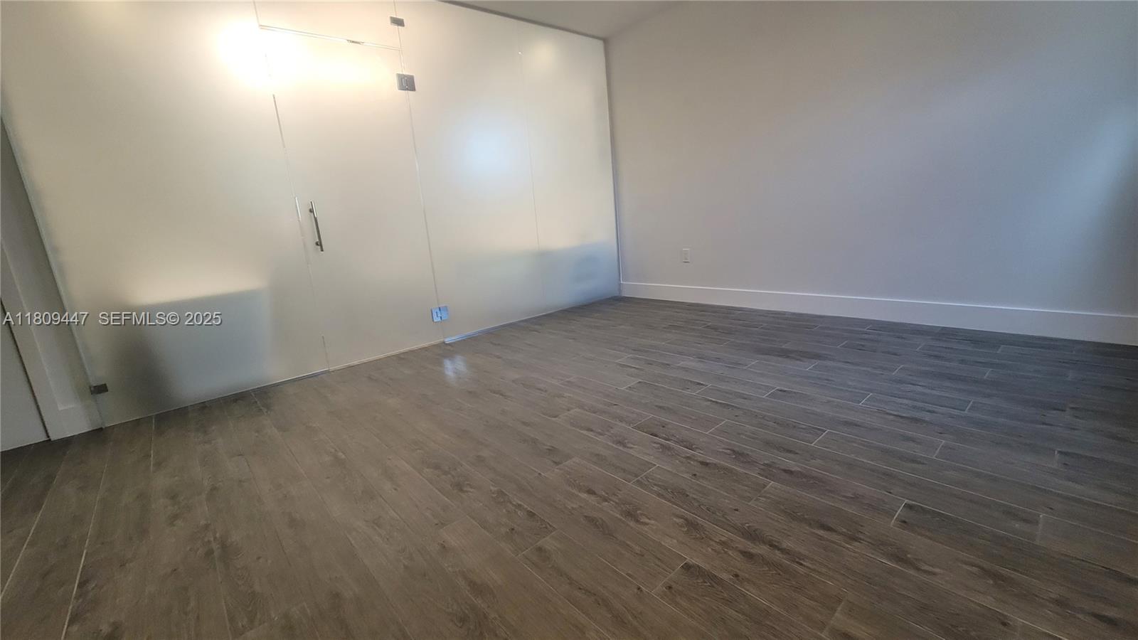 14641 Southwest 52nd Street Miami, FL 33175 - Photo 8 of 26 an empty room with wooden floor and windows