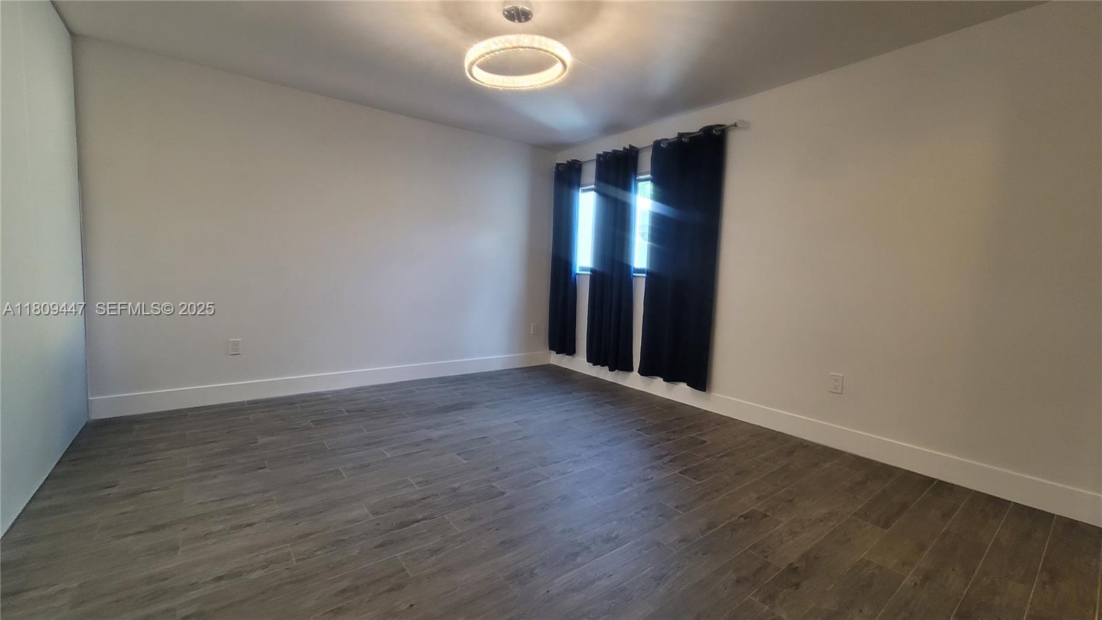 14641 Southwest 52nd Street Miami, FL 33175 - Photo 9 of 26 a view of an empty room with wooden floor and a window