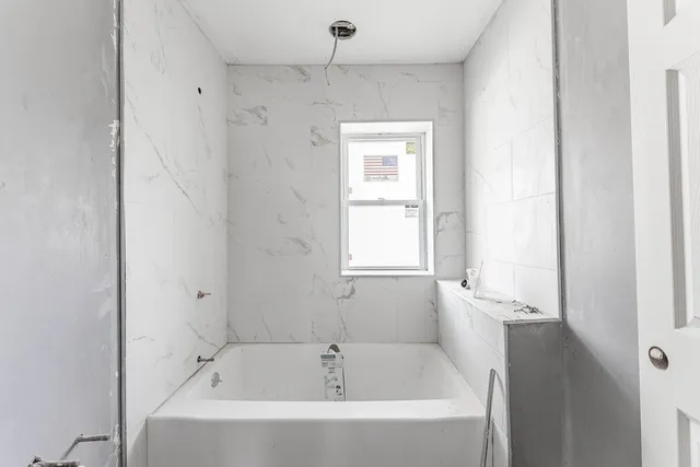 a white bath tub sitting next to a window