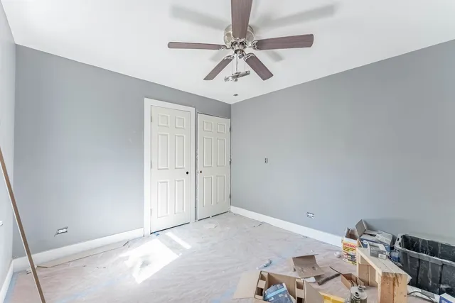a view of a workspace with furniture and a ceiling fan