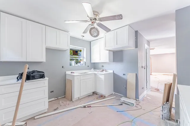 a kitchen with a refrigerator a stove top oven a sink and cabinets