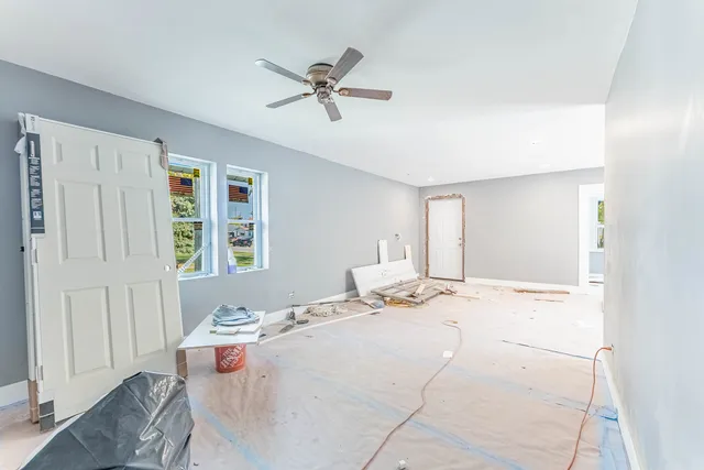 a view of a bedroom with a bed and wooden floor
