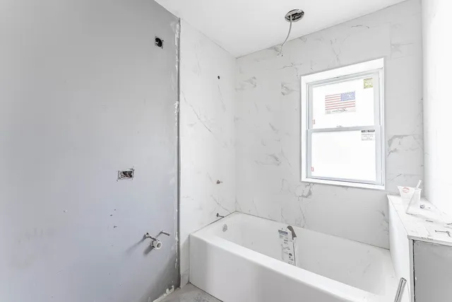 a white bath tub sitting next to a window