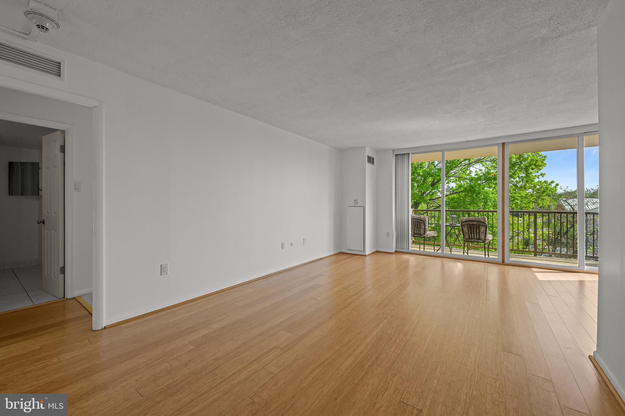 2016 Naamans Road, Unit 5E Wilmington, DE 19810 - Photo 13 of 24 a view of an empty room with wooden floor and glass door