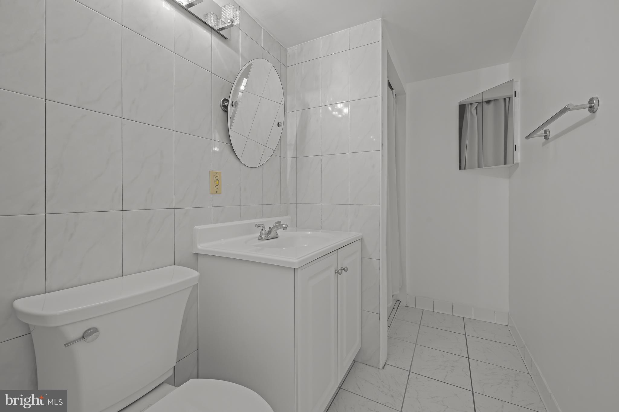 2016 Naamans Road, Unit 5E Wilmington, DE 19810 - Photo 17 of 24 a bathroom with a sink a toilet and shower