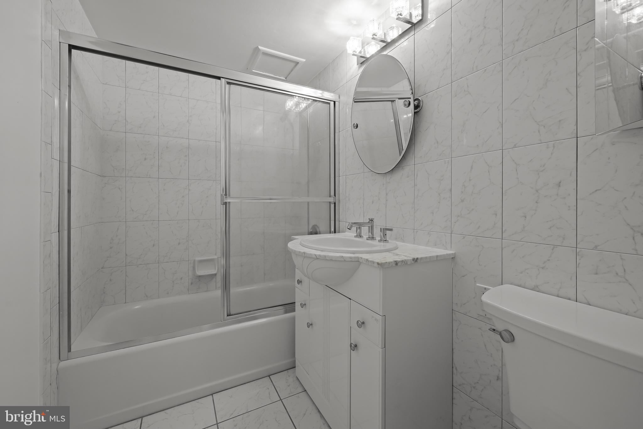 2016 Naamans Road, Unit 5E Wilmington, DE 19810 - Photo 20 of 24 a bathroom with a shower a sink and mirror