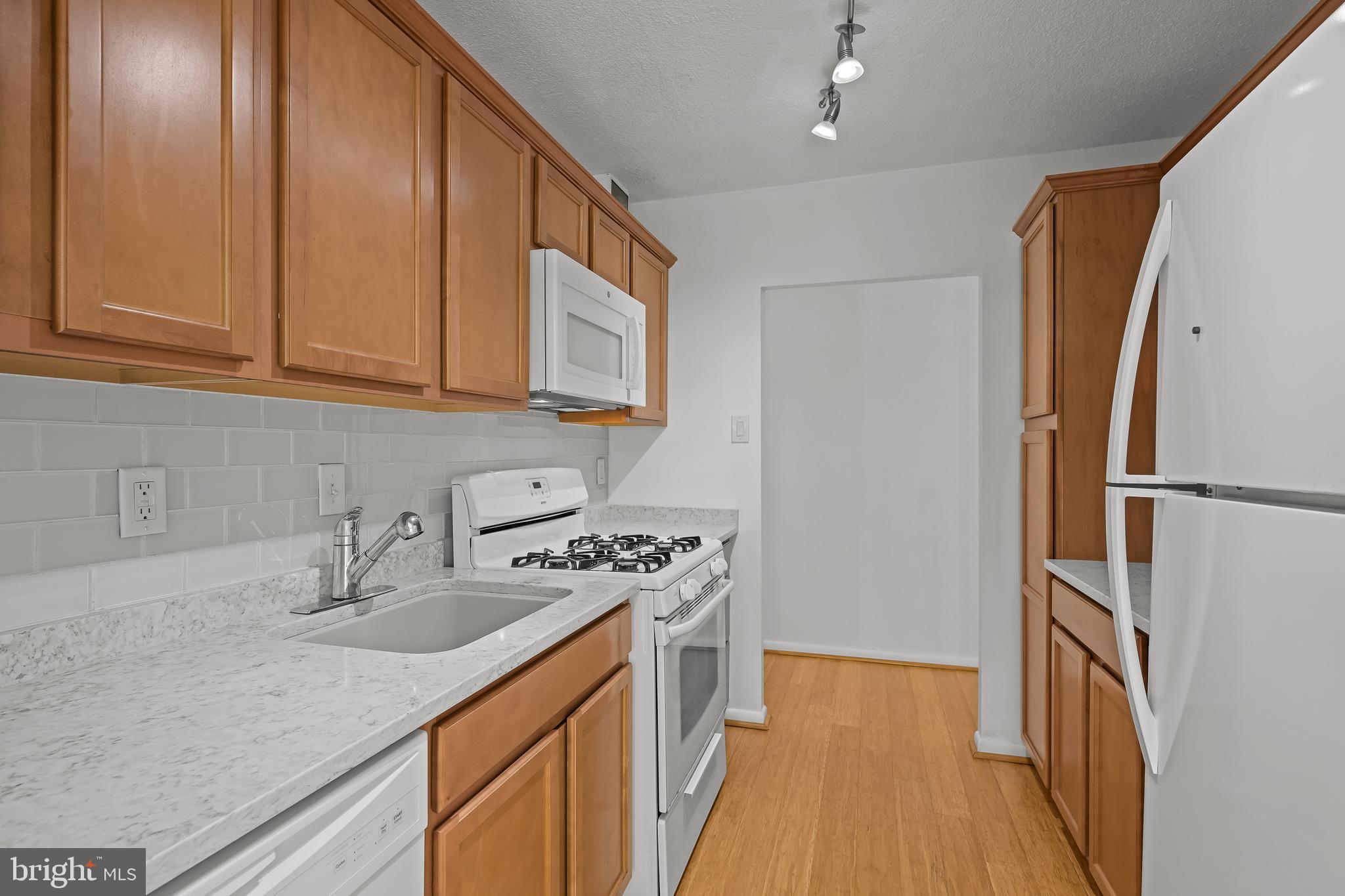 2016 Naamans Road, Unit 5E Wilmington, DE 19810 - Photo 8 of 24 a kitchen with stainless steel appliances granite countertop a sink stove and refrigerator