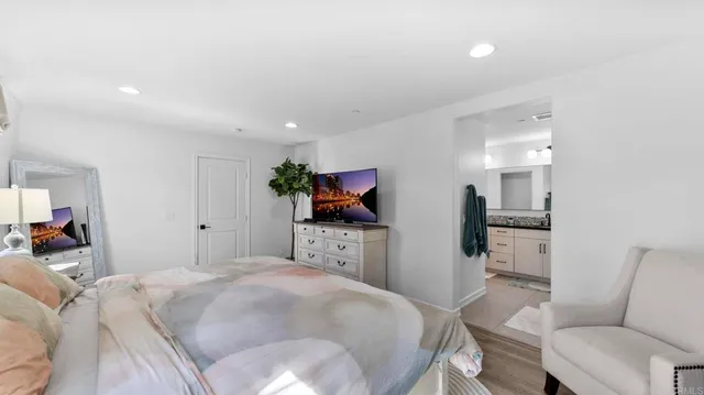 a bedroom with a bed a couch and a flat screen tv