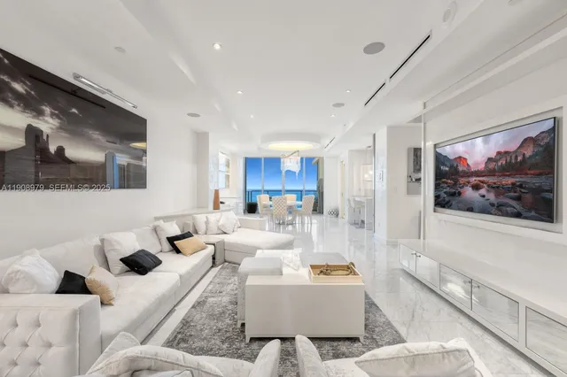 a living room with furniture and a view of kitchen