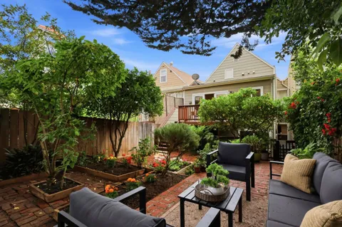 a view of a backyard with sitting area furniture and garden