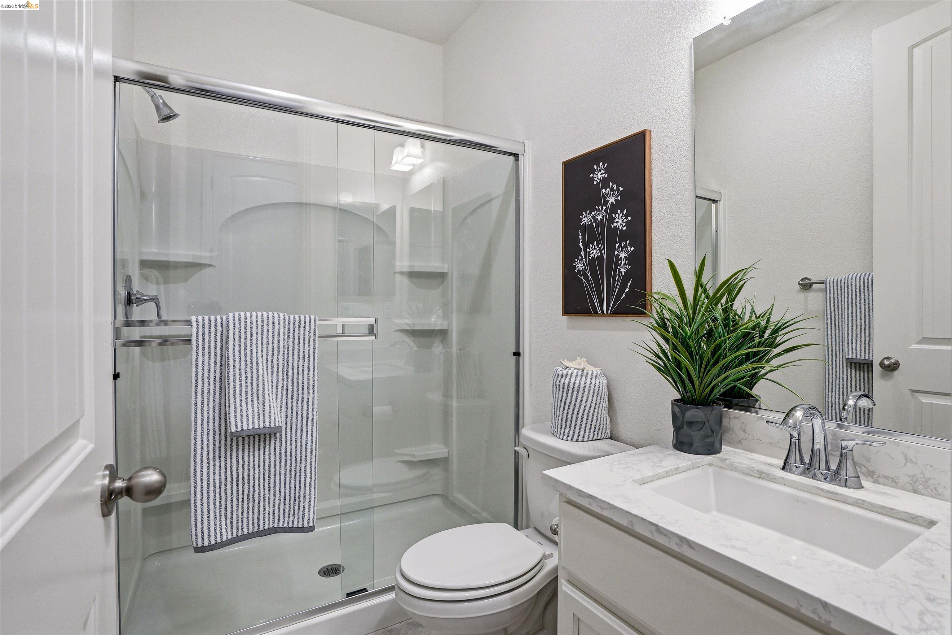 2525 Modena Drive Pittsburg, CA 94565 - Photo 26 of 34 a bathroom with a shower sink vanity mirror and toilet
