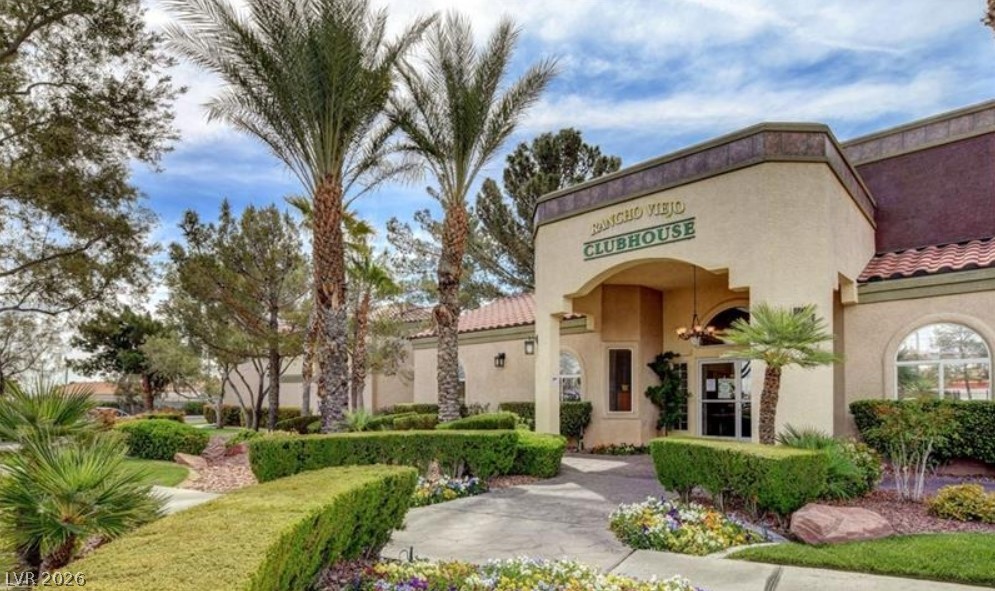 7885 West Flamingo Road, Unit 1008 Las Vegas, NV 89147 - Photo 7 of 29 Manicured landscaping surrounds the grand entrance to the community clubhouse, offering a welcoming retreat.