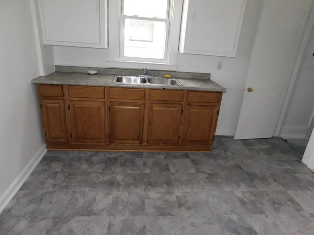 a kitchen with a sink a window and cabinets