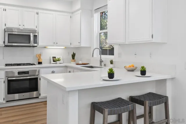 a kitchen with stainless steel appliances a stove a sink a microwave and cabinets