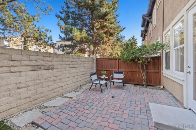a view of a patio with table and chairs with wooden fence and plants