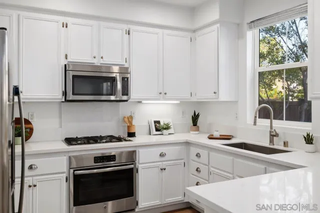 a kitchen with white cabinets and white appliances