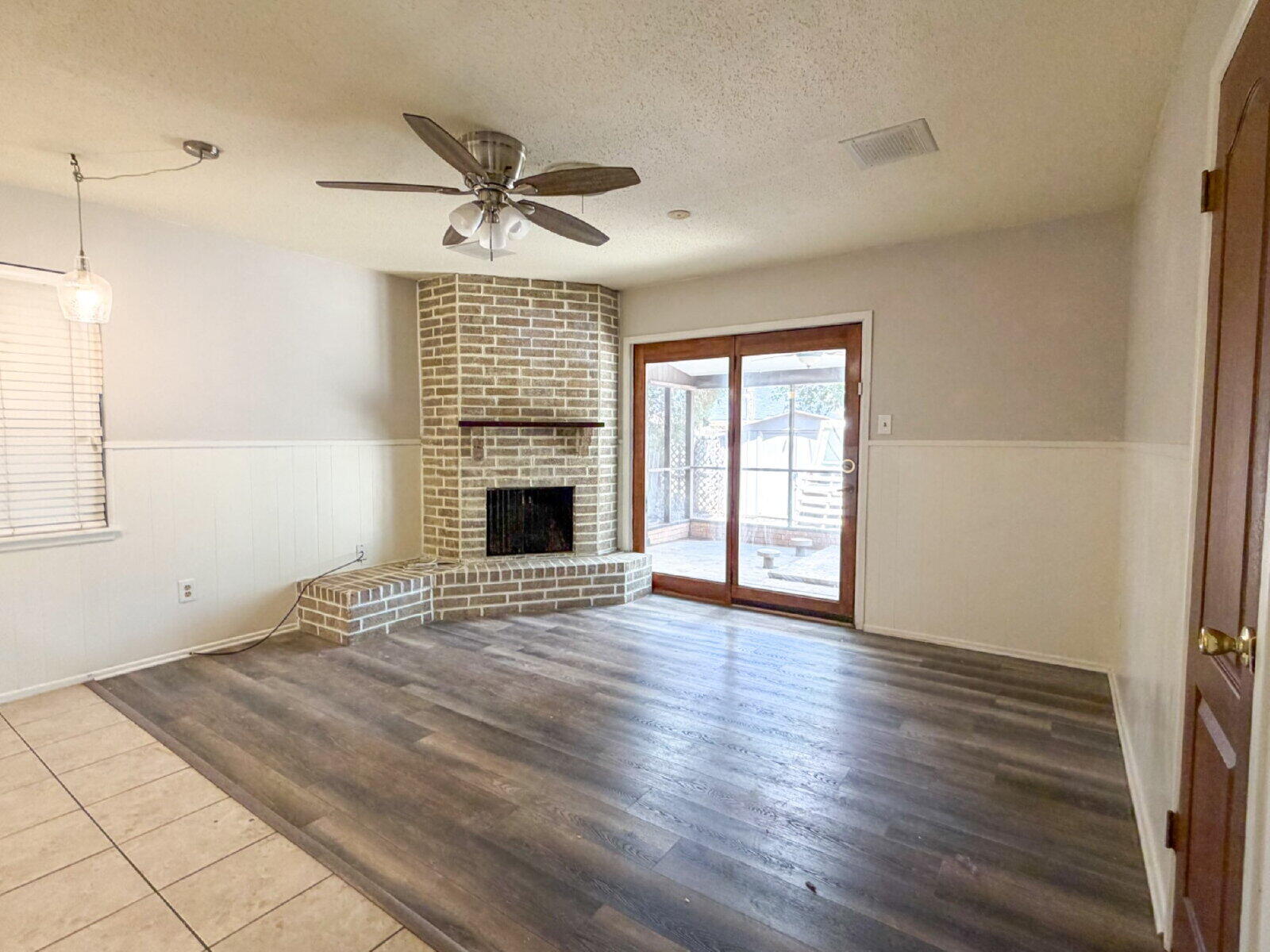 5604 38th Street Lubbock, TX 79407 - Photo 4 of 11 an empty room with wooden floor fireplace and windows