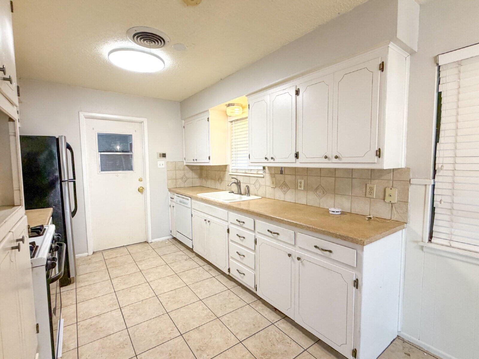 5604 38th Street Lubbock, TX 79407 - Photo 5 of 11 a kitchen with a sink window and cabinets