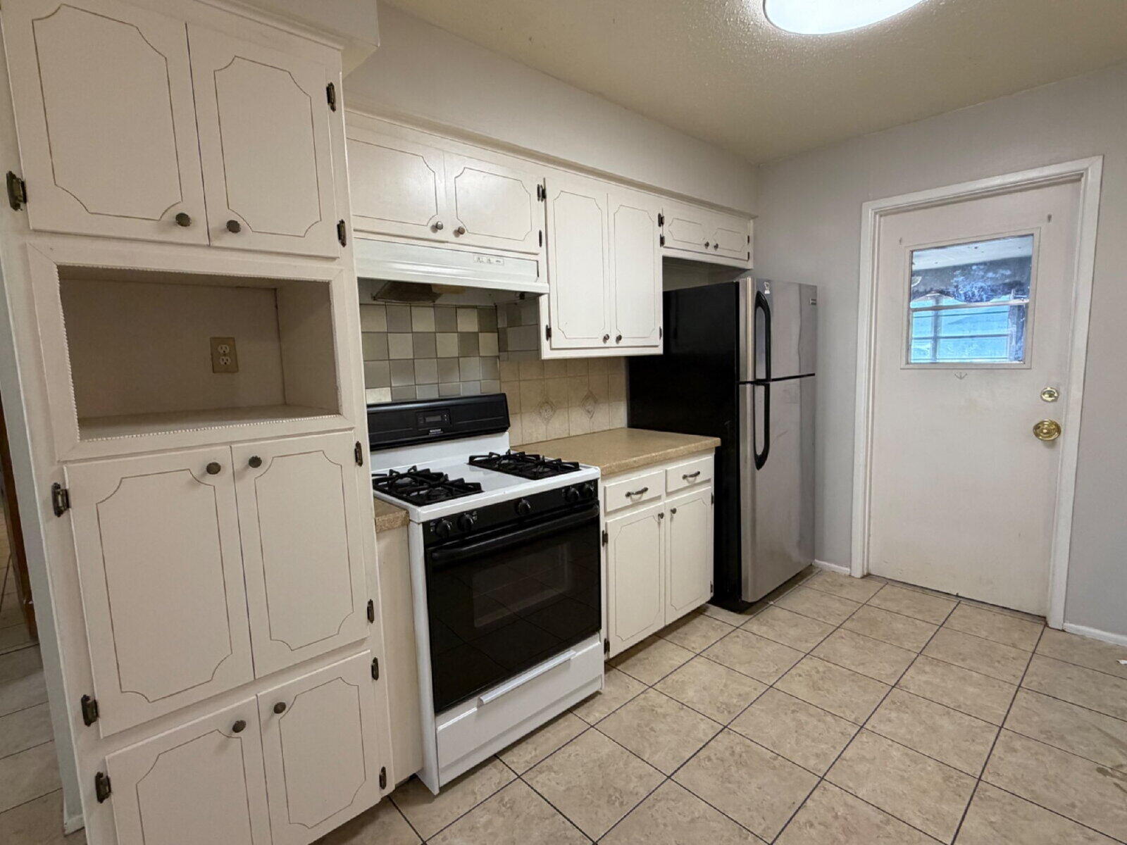 5604 38th Street Lubbock, TX 79407 - Photo 6 of 11 a kitchen with stainless steel appliances granite countertop a stove a refrigerator and a microwave