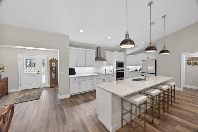 a large kitchen with stainless steel appliances kitchen island a large stove a sink a oven and a center island