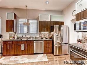 244 South Monroe Street Denver, CO 80209 - Photo 6 of 16 a kitchen with stainless steel appliances granite countertop a refrigerator and a sink