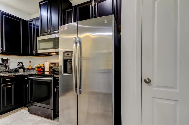 a kitchen with stainless steel appliances granite countertop a refrigerator and a sink