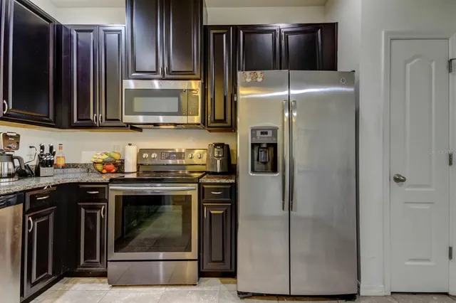 a kitchen with stainless steel appliances granite countertop a refrigerator stove and microwave
