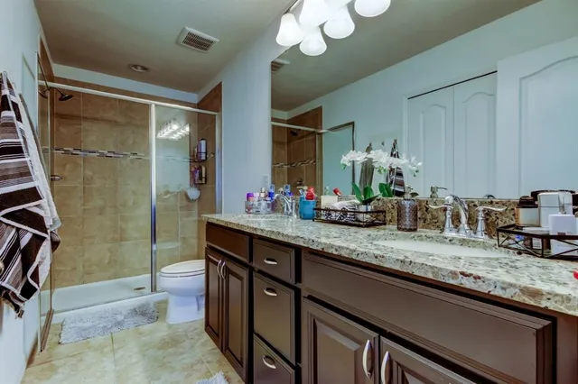 a bathroom with a granite countertop sink a mirror and a shower