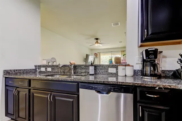 a kitchen with stainless steel appliances granite countertop a sink and cabinets