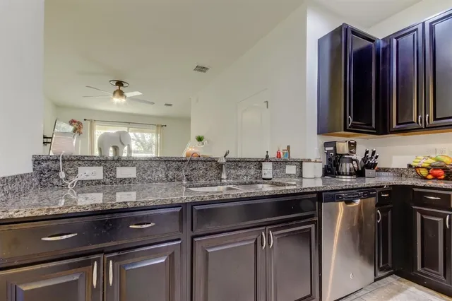 a kitchen with stainless steel appliances granite countertop a sink stove and cabinets
