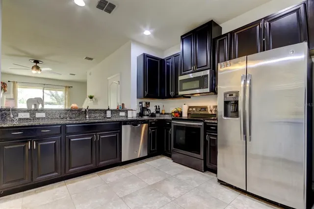 a kitchen with stainless steel appliances granite countertop a refrigerator and a sink