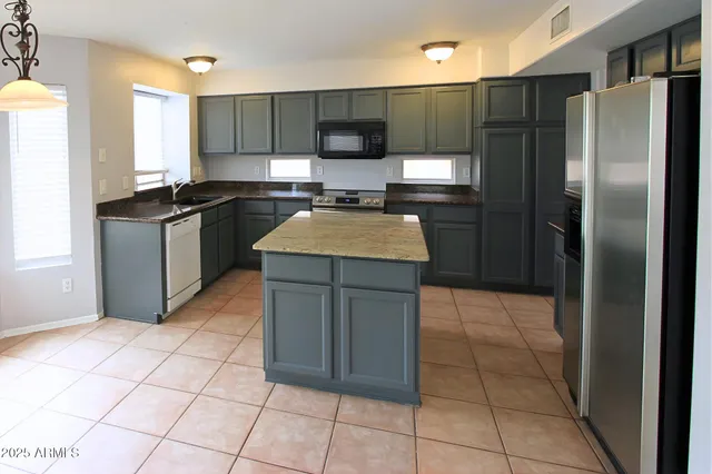 a kitchen with stainless steel appliances granite countertop a refrigerator and a stove