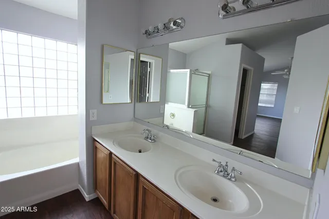a bathroom with a tub sink and mirror