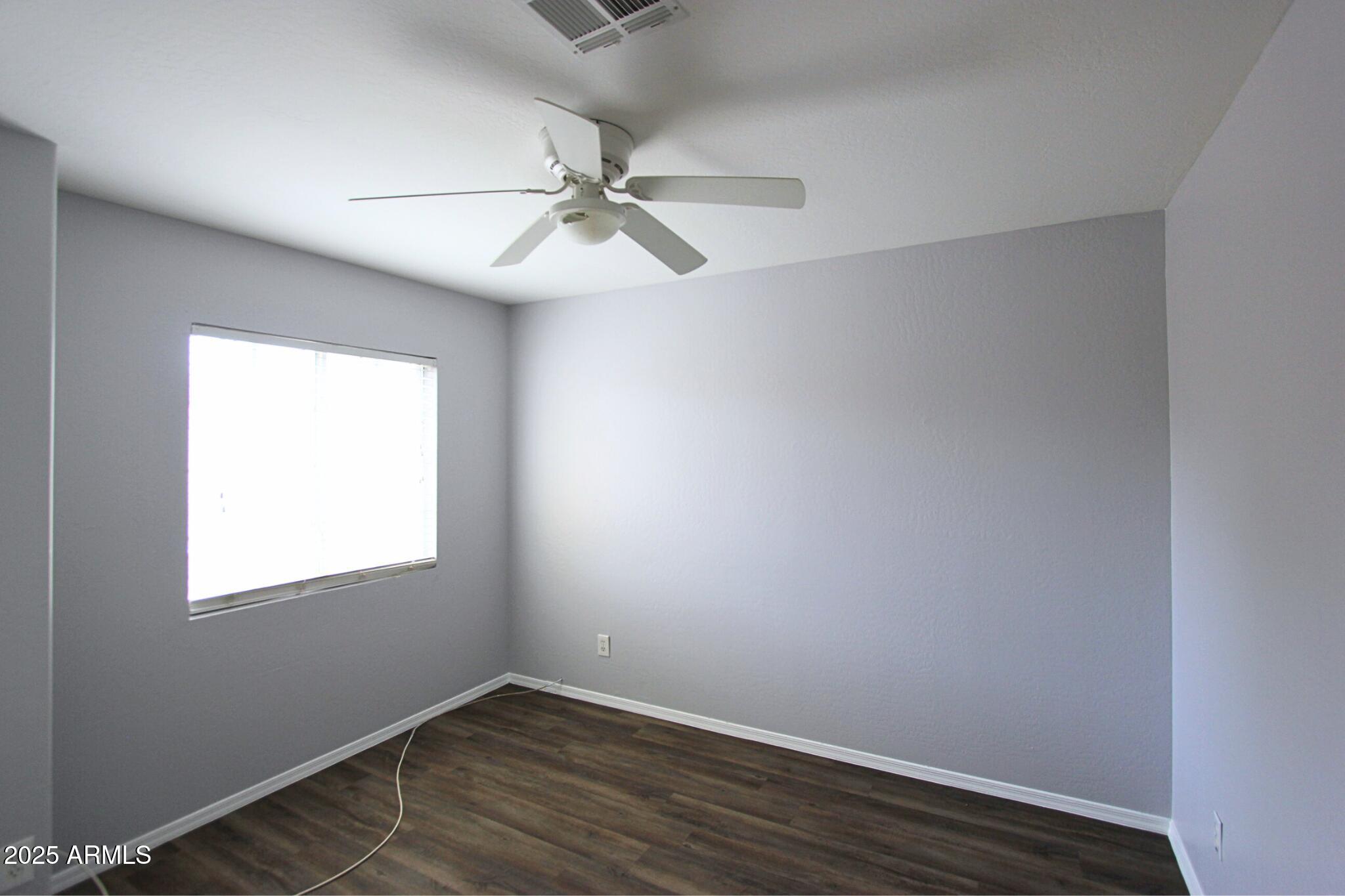 1115 South Tiago Drive Gilbert, AZ 85233 - Photo 16 of 22 an empty room with wooden floor fan and windows