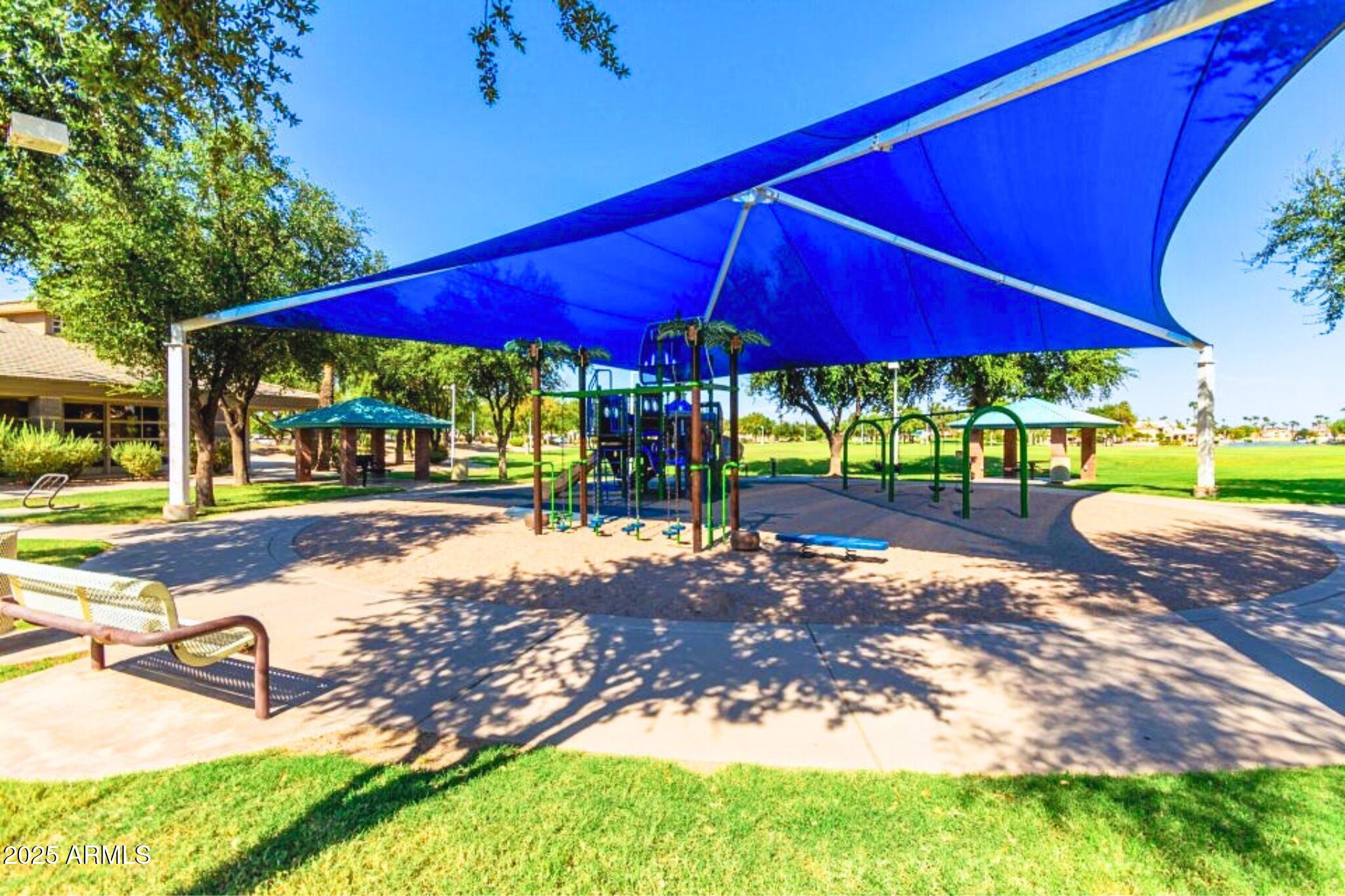 1115 South Tiago Drive Gilbert, AZ 85233 - Photo 18 of 22 a view of a swimming pool with red chairs under an umbrella