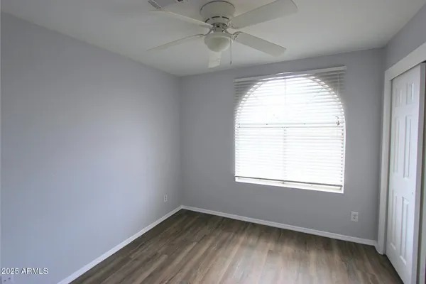 an empty room with a window and a fan