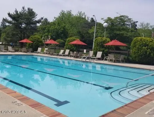 a view of house with swimming pool and outdoor seating