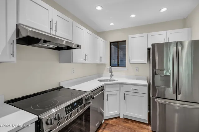 a kitchen with granite countertop a stove and a wooden floors