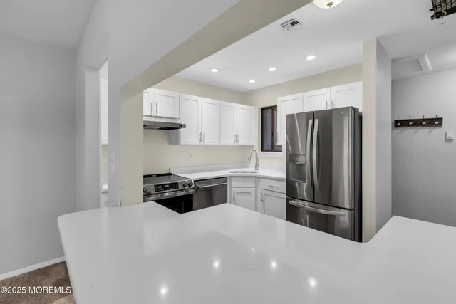 a kitchen with stainless steel appliances a sink stove and refrigerator