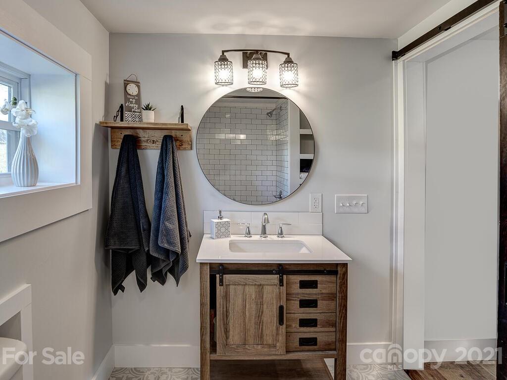 36 Center Pigeon Road Canton, NC 28716 - Photo 27 of 30 a bathroom with a sink a vanity and a mirror