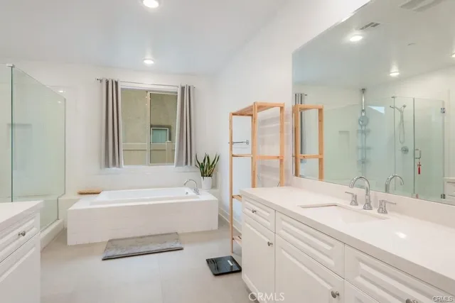 a bathroom with a bathtub a sink and a large mirror