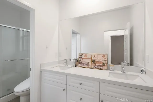 a bathroom with a double vanity sink mirror and toilet